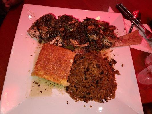 Fried snapper topped with creole shrimp side of rice and peas and Macaroni pie