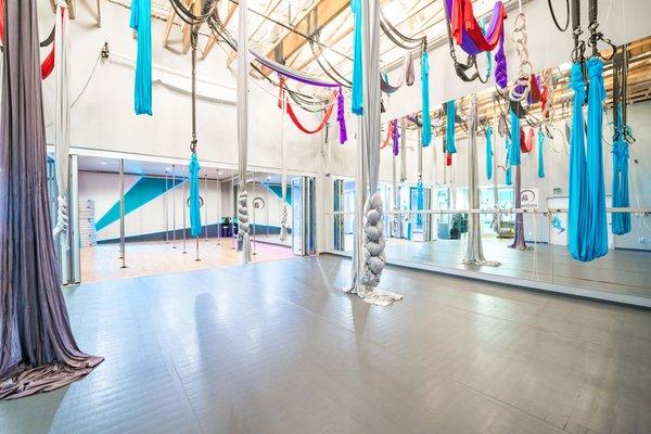 Aerial fitness room with a custom padded floor for added safety. Beams hold 30,000 pounds and OSHA certified for safety