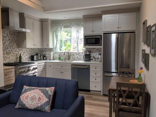 Stone wood grain floors, white quarts countertop, 2x2 marble style grey/white hexagon "Loft" tile backsplash