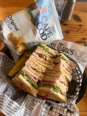 Club sandwich with kettle chips and kosher dill pickle strip.