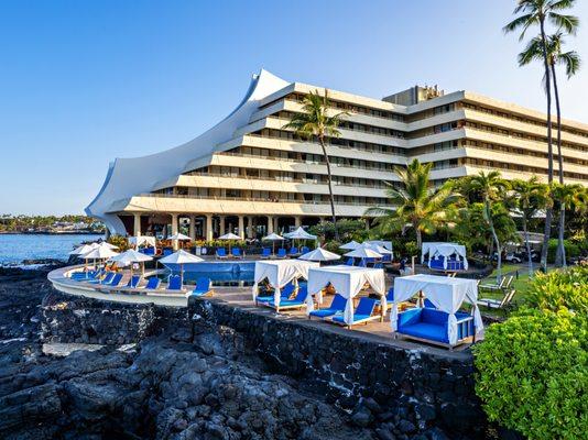 Pool cabanas on the pool deck with the Royal Kona Resort in the background