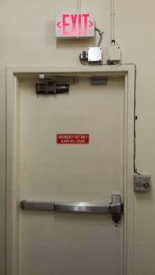 On this door, I installed a panic bar, a fire alarm, and a door closer.