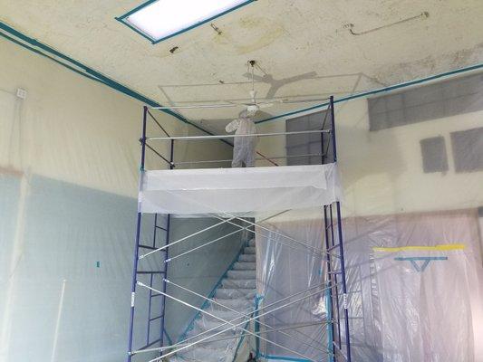 Scraping acoustical spray from a 18 foot ceiling.