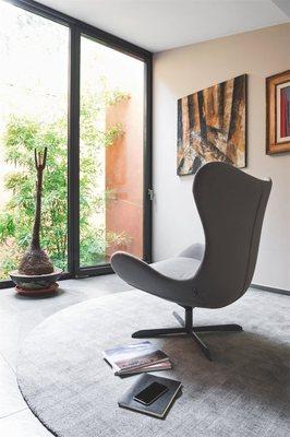 LAZY is an armchair with curved lines and large, comfortable seat, perfect for relaxing in.