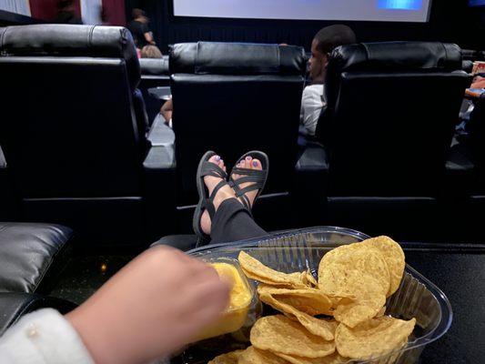 Feet up and snacking.