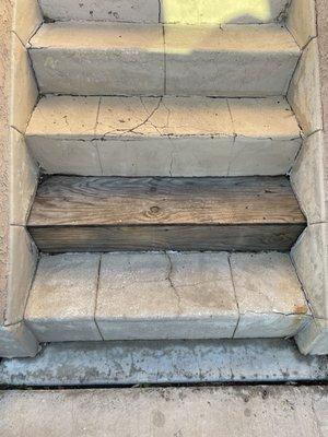 Bottom of stairs. Exposed dry rotted wood they refused to fix