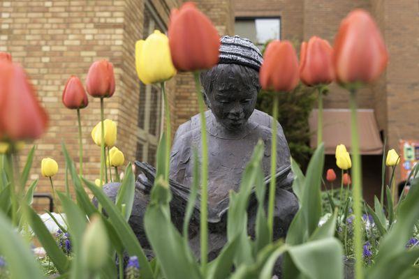 Sculpture out front of the building is surrounded by tulips in the spring.