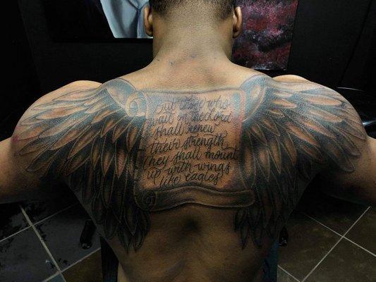 Script and wings tattoo by Jesse