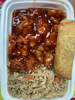 Simple plate with orange chicken, fried rice, and pork egg roll.