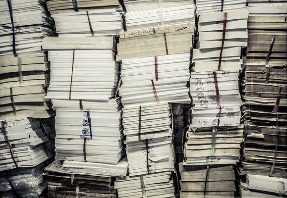 Stacks of files in a closet that need shredding