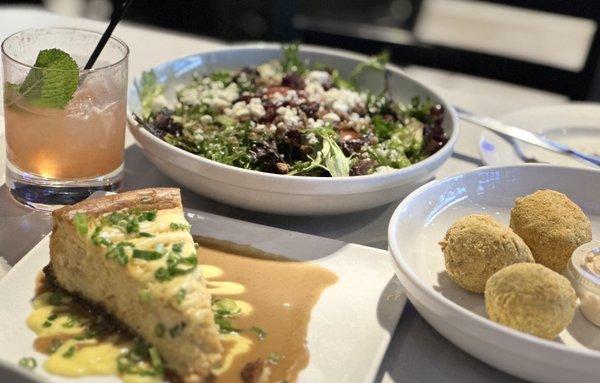 Boudin balls, savory crawfish  cheesecake, salad and tasty adult beverage.