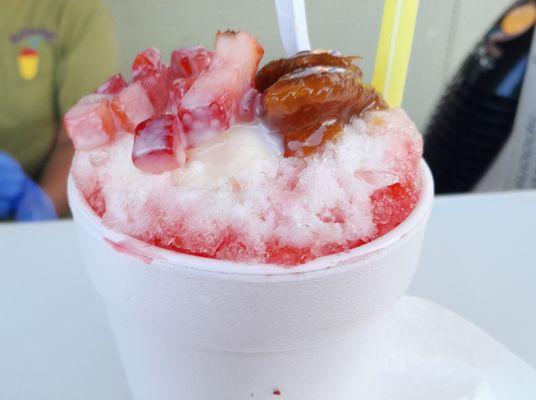 Raspa (Mexican Shaved Ice) topped with fresh strawberry, tamarind and a drizzle of sweet condensed milk.  Pineapple and strawberry syrup too