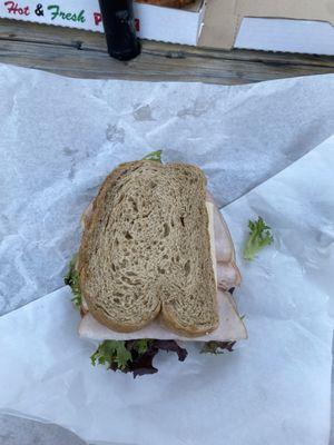 Turkey sandwich with tomato, Swiss cheese, and arugula lettuce on multigrain bread