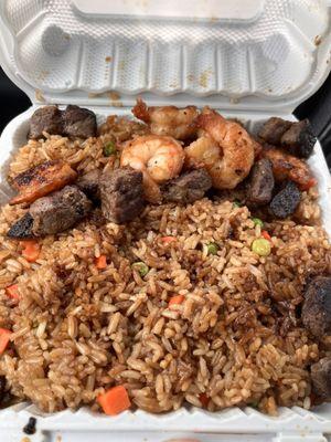 Steak and shrimp fried rice with peas and carrots plate