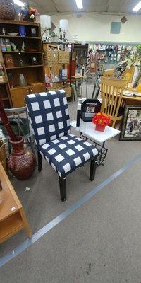 Close up of a nice upholstered chair and side table.