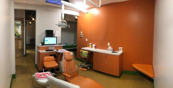 Orange Treatment Room with Sitting Area and Television on Ceiling