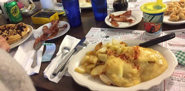 Eggs Benedict with American fries, and chocolate chip waffles in the background...pretty solid breakfast!