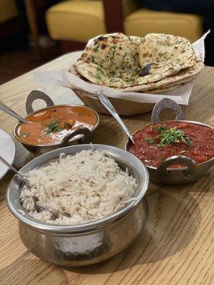 Naan Basket, Paneer Tikka Masala (orange sauce), Chicken Vindaloo (red sauce), side dish of rice.