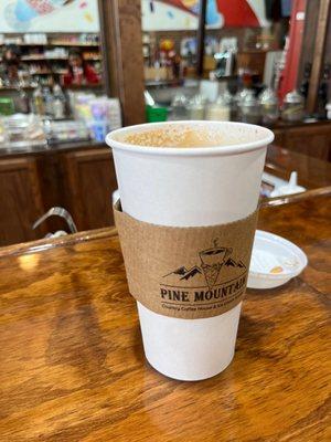 Large Chai Latte; barista bar in back.