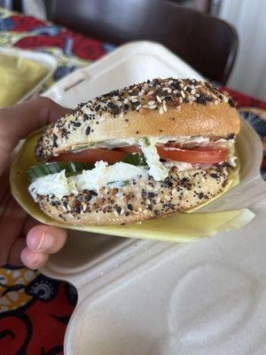 Everything bagel with scallion cream cheese and added tomato and cucumber