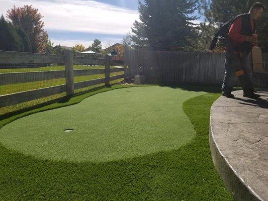 Small synthetic putting green in yard.