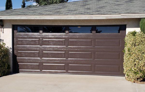 New Brown 16x7 two car garage door with windows, weather stripping and quiet glide rollers and hinges installed.