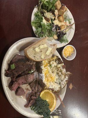 Loaded baked potato with filet mingon, bread and side salad.