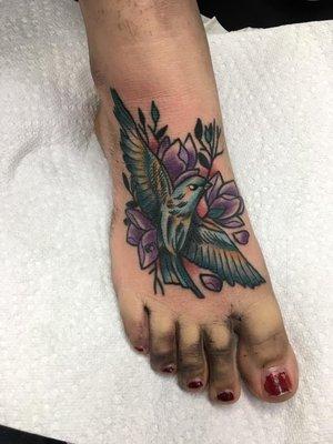 A bird tattoo with a unique style and water color feel to it.