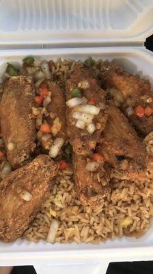 Salt and pepper chicken wings over fried rice.