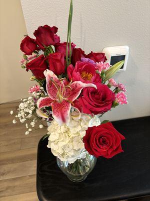 "A Bouquet of Red Roses and Pink Lily in a Clear Vase."