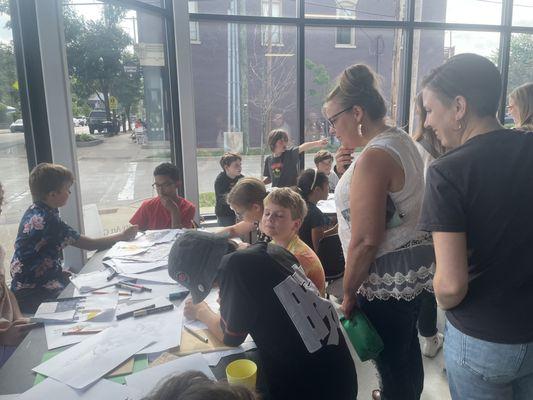 Adults viewing the work of students at an art class at Cultivate in Grand Rapids