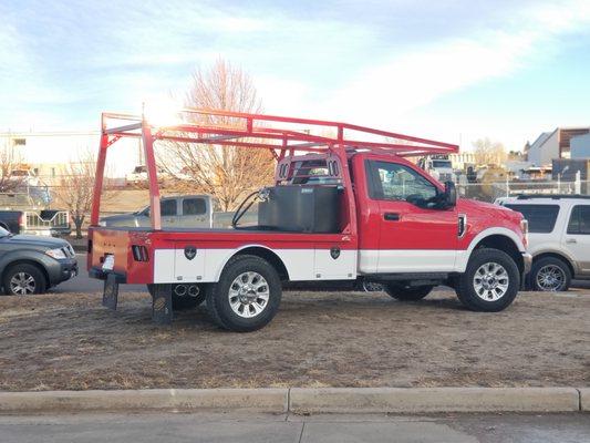 A Ledom's GL flatbed with with removable ladder rack and extra fuel tank added.