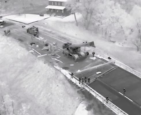 Thermal image of construction crew working at night on a bridge.