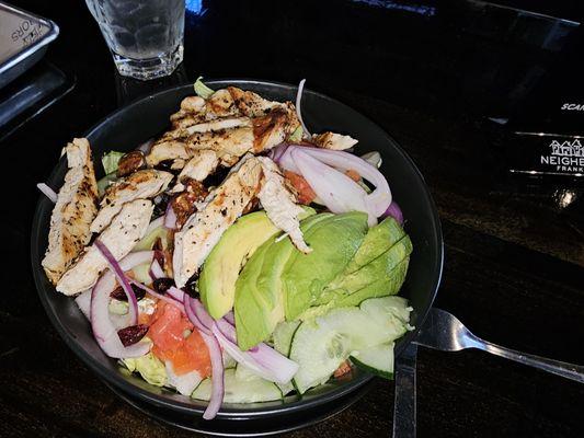 Grilled chicken on top of chopped lettuce, avocados, diced tomatoes, cucumber, red onion, candied pecans, dried cranberries