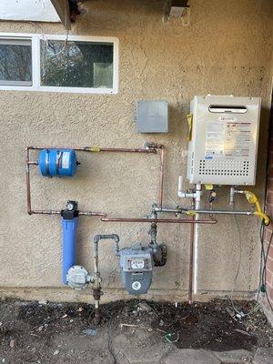 A properly installed tankless water with a water heater treater filter, expansion tank, and a weather proof box for the remote control.