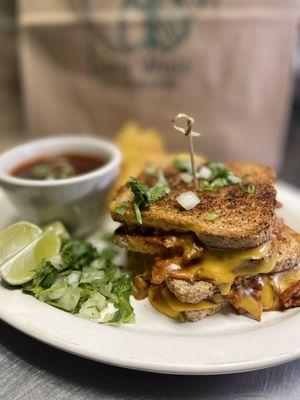 Birria Grilled Sandwich served with dipping consomé & taco fixings.