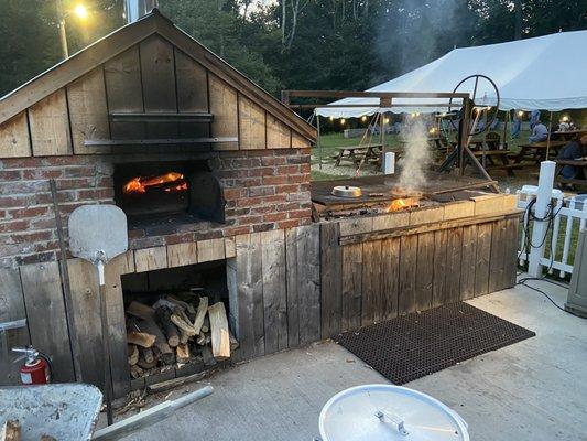 Pizza oven and grill out near the seating area.