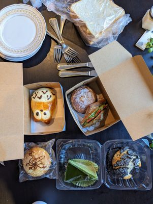 From top going clockwise: Shokupan, Azuki cream, Matcha Ichigo, Black sesame pan, Green tea cake, tuna roll, totoro bun