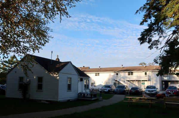 A backlot view of one of their cottages and the back of hotel and parking lot.