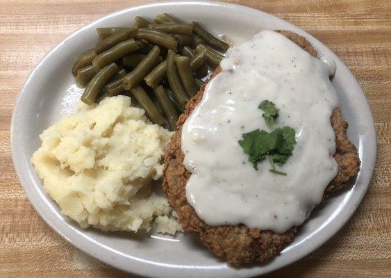 Homemade chicken fried steak served with potatoes and green beans!