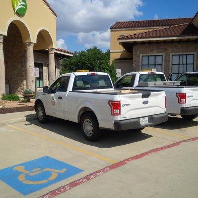 Employee trucks parked in 15 minute limit set aside for customers.