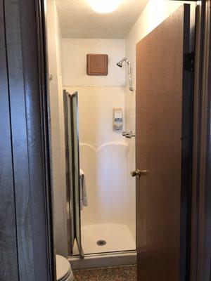 Small shower stall but the shower head has been raised to accommodate those over 6ft.