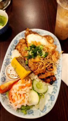 Rice plate with fried egg, meatloaf, pork chop and bi.