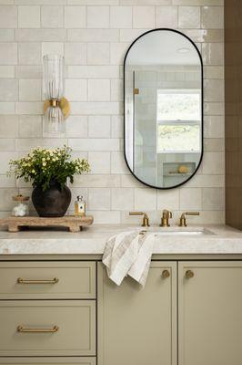 Primary bath remodel with custom cabinetry, quartzite countertop, wall sconces, brass plumbing and zellige style tile