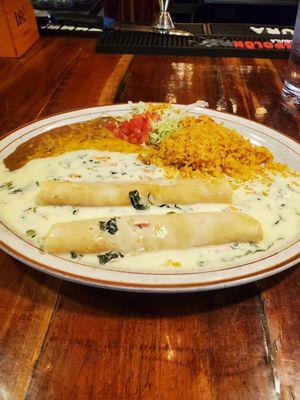 Two cheese and onion enchiladas with queso ( white cheese sauce) refried beans and rice. It was so good!!!