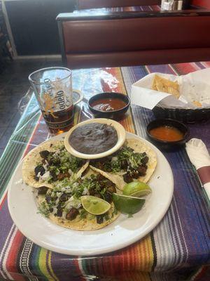 Al Pastor tacos black refried beans homemade tortilla chips. Home made hot sauce and homemade salsa.