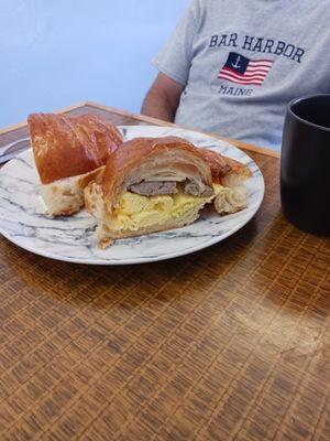 egg and sausage on a croissant.