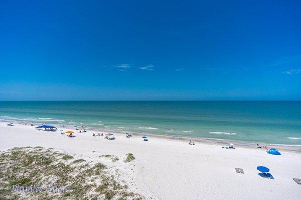 A view the white sandy beach and turquoise waters of the Gulf of Mexico from a private balcony of a Chateaux condo.