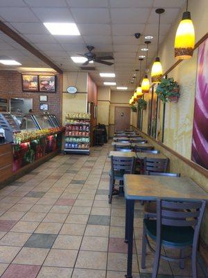 Dining area in front of order counter; restrooms in far background.