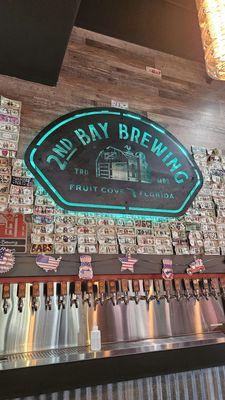 The brewery logo and their wall of taps